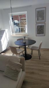 ein Wohnzimmer mit einem Tisch, Stühlen und einem Sofa in der Unterkunft Ein Haus für sich in Lübeck