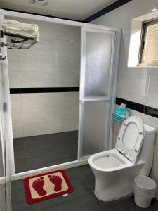 a bathroom with a shower with a toilet and a sink at Tianen Farm in Hualing