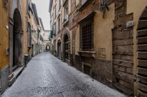 an empty street in an alley between buildings at casa Giovanna - Piazza San Michele Central Studio! in Lucca
