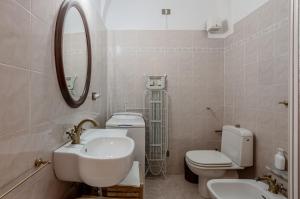 a bathroom with a sink and a toilet and a mirror at casa Giovanna - Piazza San Michele Central Studio! in Lucca