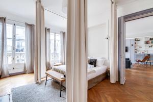 a white room with a bed and a couch at Sweet Inn - Rue de Ponthieu in Paris