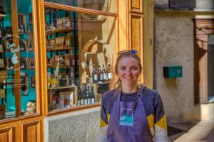 a woman wearing an apron standing in front of a store at Chalet Beaufortain La Pachna in Hauteluce