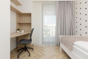 a bedroom with a desk and a bed and a chair at Cozy & Spacious Family Apartment by Renters in Warsaw