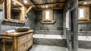 a bathroom with a tub and a sink and a tub and a bath tub at Chalet Chal'heureux in Chamonix-Mont-Blanc +34 photos
