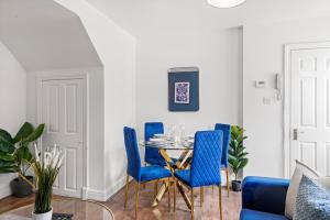 comedor con sillas azules y mesa en Camden Cottage, 2 Bedroom house in Camden Town, en Londres