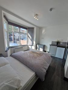 una camera con un grande letto e una finestra di Room On Southall High Street a Southall