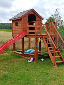a playground with a slide and a play house at DOMEK LETNISKOWY PRZY GÓRACH MAJOWYCH in Goniadz