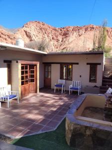 eine Terrasse mit zwei blauen Stühlen und einem Gebäude mit einem Berg in der Unterkunft ALQUILER TEMPORARIO EN PURMAMARCA in Purmamarca