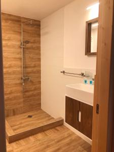 a bathroom with a shower and a white sink at Boutique hotel mestia in Mestia