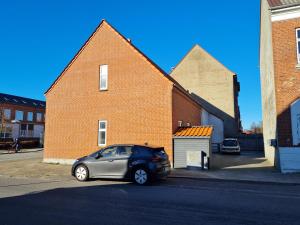 a small car parked in front of a brick building at (id024) Østergade 87. 1 tv in Esbjerg