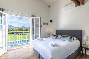 ein Schlafzimmer mit einem großen Bett und einem großen Fenster in der Unterkunft Magnifique Villa face à la Rhune in Ascain