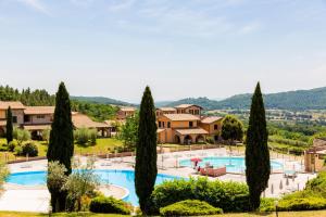 a resort with a swimming pool and trees at Pian Dei Mucini Resort in Massa Marittima