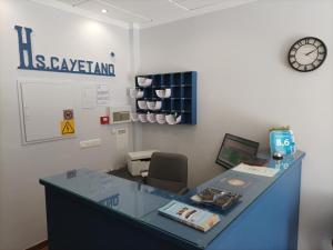 an office with a desk with a clock on the wall at Hostal San Cayetano in Ronda