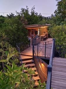 a wooden deck with a house in the woods at El Violin Experiencia Adults only in Melegis