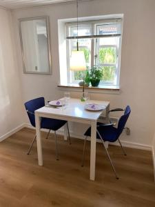 a white dining room table with chairs and a window at Ferielejlighed til 2 personer in Ebeltoft +6 photos