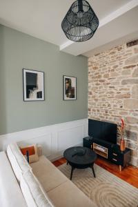 a living room with a couch and a brick wall at Les Balcons de Kéréon in Quimper