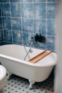 uma banheira na casa de banho com azulejos azuis em Les Balcons de Kéréon em Quimper