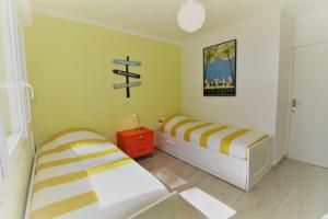 1 dormitorio con 2 camas y un cartel en la pared en La Cigale Sanaryenne classé 4 étoiles face à un jardin méditerraneen, en Sanary-sur-Mer