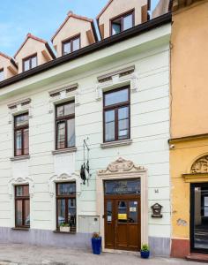 a white building with windows and a door at Garni Hotel VIRGO in Bratislava