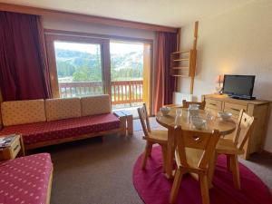 a living room with a table and a couch and a television at Studio 4 pers. au pied des pistes à Méribel Altiport, animaux admis - FR-1-411-397 in Les Allues