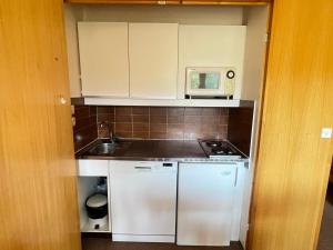 a small kitchen with a sink and a microwave at Studio 4 pers. au pied des pistes à Méribel Altiport, animaux admis - FR-1-411-397 in Les Allues +7 photos
