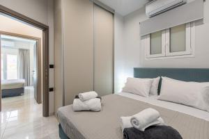 1 dormitorio con 1 cama con toallas en Neaira City Apartment Near The Beach, en La Canea