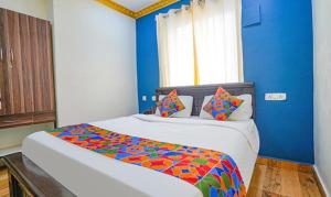 a bedroom with a large bed with a colorful comforter at FabExpress Lloyds Inn in Chennai