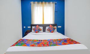 um quarto com uma cama grande e paredes azuis em FabExpress Lloyds Inn em Chennai