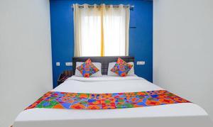 a bedroom with a large bed with blue walls at Fab Express Lloyd's Inn - Near Kodambakkam Railway Station in Chennai
