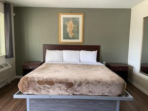 a bedroom with a large bed with two night stands at Paris Extended Stay Suites in Paris