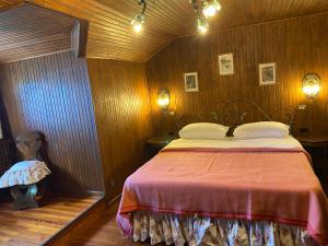 ein Schlafzimmer mit einem Bett in einem Holzzimmer in der Unterkunft Chalet Miralago in Plesio