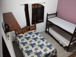 a bedroom with two bunk beds and a window at Casa ilha comprida in Ilha Comprida