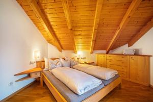 ein großes Bett in einem Zimmer mit Holzdecke in der Unterkunft Adults Only Wasserfall Hegedex in Pfunders