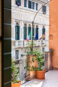 a building with flags on a balcony with plants at Charming Palace Santa Fosca in Venice