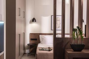 a bedroom with a bed and a potted plant at Ermioni Luxury Suite Beachfront 1 minute from the beach in Stalida