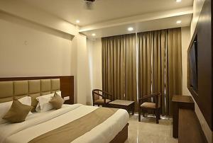 um quarto de hotel com uma cama e uma televisão em Hotel Amansara em Lucknow