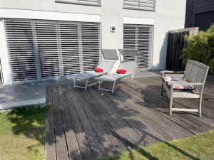 a deck with two chairs and a bench on it at Ferienhaus Sonnenhaus in Bodman-Ludwigshafen