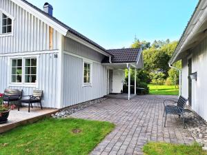 eine Terrasse mit 2 Stühlen und ein Haus in der Unterkunft Fresh villa in Harryda near Landvetter airport and golf course in Härryda