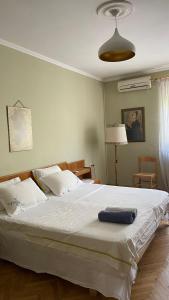 ein großes weißes Bett mit blauem Handtuch darauf in der Unterkunft Scanderbeg Square Apartment in Tirana