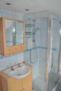 a bathroom with a sink and a shower at Nice 3 Bedroom House Ealing in London