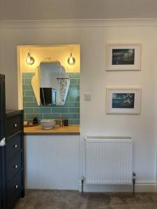 a bathroom with a sink and a mirror on the wall at Lavender Cottage with a hot tub in Deganwy