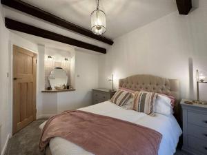 a bedroom with a large bed in a room at Lavender Cottage with a hot tub in Deganwy