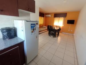 a kitchen with a white refrigerator and a dining room at Los Abuelos 17 in General Pico