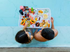 un niño y una niña sentados en una mesa con comida en Imperatriz Paraty Hotel, en Paraty