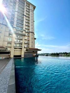 un gran edificio junto a una gran masa de agua en Elegant Riverine Diamond Homestay With Pool, en Kuching