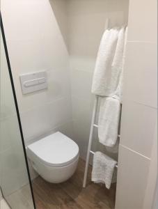 Baño blanco con aseo y toallas en Apartamento Palau Cadaques en Cadaqués