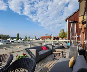 a rooftop deck with couches and tables and a highway at Vänerport Lakefront Hotell in Mariestad
