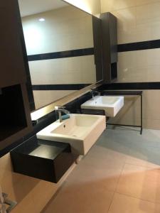 a bathroom with two sinks and a mirror at Luxurious Villa with BBQ & JACUZZI By The Beach Batu Ferringhi in Batu Ferringhi