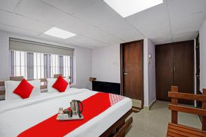 a bedroom with a large bed with red pillows at OYO Flagship Dreamy Sunrise By Stayapart Near City Centre Salt Lake in Kolkata