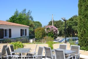 un groupe de tables et de chaises devant une maison dans l'établissement Camping Parc Valrose, à La Londe-les-Maures